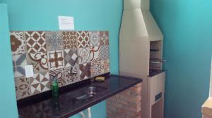 eine Küche mit Spüle und Ziegelwand in der Unterkunft Atlântico in Maresias