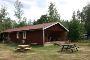 a red cabin with picnic tables in front of it at Modal Annex in Hultsfred