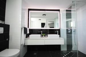 a bathroom with a sink and a toilet and a mirror at Apartments Tomaš in Makarska
