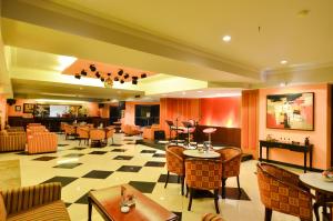 a lobby with tables and chairs and a restaurant at Sari Ater Kamboti Hotel Bandung in Bandung