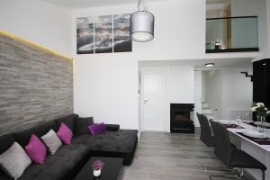 a living room with a black couch and purple pillows at Apartments Tomaš in Makarska