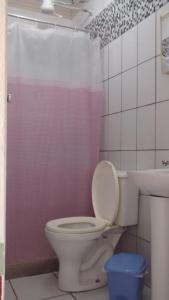 uma casa de banho com um WC e um lavatório em Pousada Enseada do Coqueiro em Guarapari