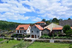 a group of houses on a hill with a yard at Just Natur Guesthouse in Castro Laboreiro