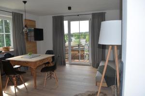ein Wohnzimmer mit einem Tisch und ein Zimmer mit einem Esszimmer in der Unterkunft Die Herberge in Mauth