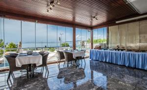 a dining room with tables and chairs and large windows at Buyukada Comfort OTEL in Buyukada