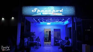 a restaurant with a blue neon sign in the dark at Spacepod@com in Singapore