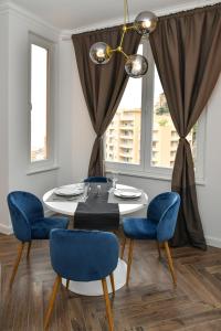ボーソレイユにあるLuxury Apartment next to Monte Carloのダイニングルーム(テーブル、青い椅子付)