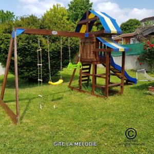 a swing set in a yard with a playground at Gîte La mélodie in Longueville