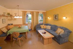 a living room with a blue couch and a table at Ferienhof Hübner in Bad Berneck im Fichtelgebirge