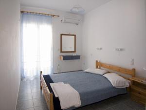 a bedroom with a bed and a mirror and a window at Folies in Lourdata