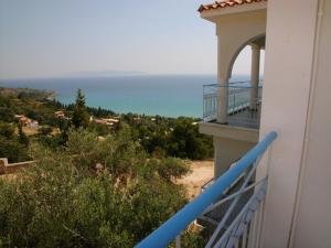 a balcony of a house with a view of the ocean at Folies in Lourdata