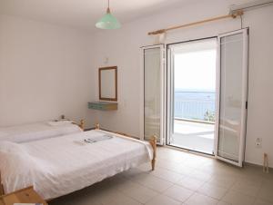 a bedroom with two beds and a large window at Folies in Lourdata