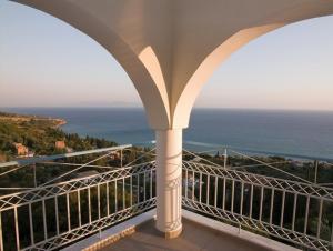 a balcony with a view of the ocean at Folies in Lourdata