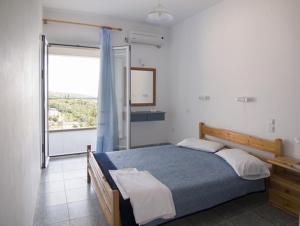 a bedroom with a bed and a large window at Folies in Lourdata