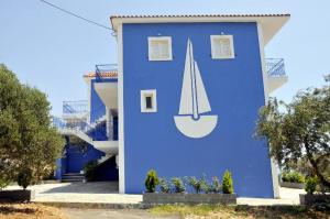 a blue building with a sailboat painted on it at Folies in Lourdata