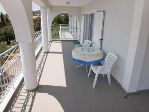 a balcony of a house with a table and chairs at Folies in Lourdata