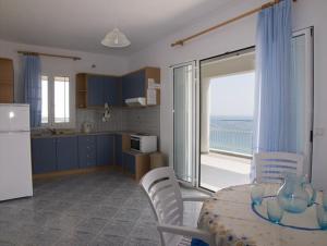 a kitchen with a table and a kitchen with a view of the ocean at Folies in Lourdata