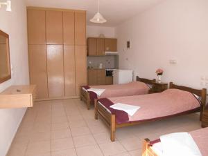 a room with two beds and a kitchen at Folies in Lourdata