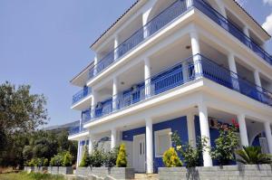 a large white building with blue balconies on it at Folies in Lourdata