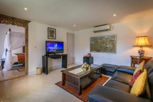 a living room with a couch and a tv at Hevea Villas in Seminyak