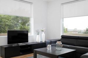 sala de estar con sofá negro y TV en Blue Luxury Apartments en Reikiavik