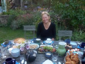 Eine Frau, die an einem Tisch voller Essen sitzt. in der Unterkunft La Tour in Marcilly-la-Gueurce