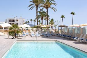 una piscina con sillas y sombrillas en un complejo en Hotel Sabina Playa, en Cala Millor