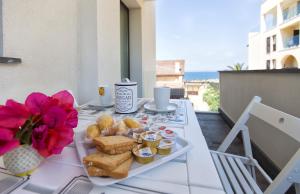 una mesa con una bandeja de comida en el balcón en Balaguer House, en Alghero