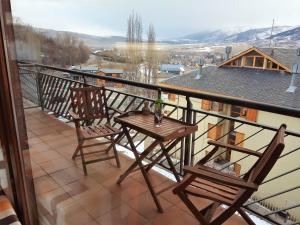a balcony with two chairs and a table at Apartamento Mirador Del Puigmal in Puigcerdà