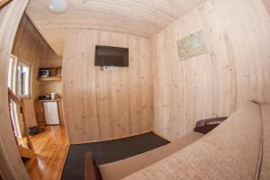 Habitación pequeña con cama y TV en la pared. en Ostrivky, en Svityazʼ