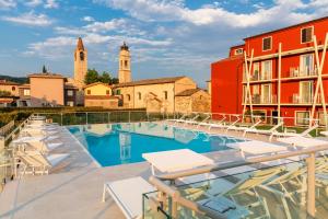 um hotel com uma piscina com cadeiras e edifícios em Hotel Speranza em Bardolino