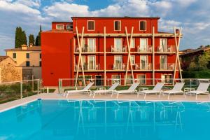 a hotel with a swimming pool in front of a red building at Hotel Speranza in Bardolino