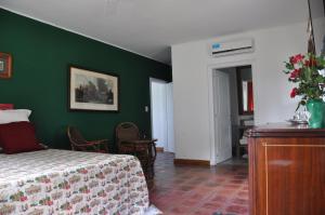 a bedroom with a bed and a green wall at Posada La Serena in Tandil +16 photos