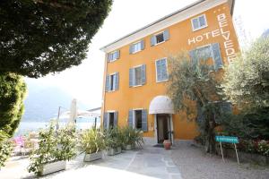 ein gelbes Gebäude mit einem Schild, das Hotel liest in der Unterkunft Villa Belvedere Como Lake Relais in Argegno