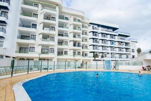 una piscina frente a un edificio en Apartamento T2 com Piscina e Wifi a 350 metros da Praia, en Roja- Pé