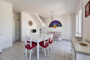 een keuken en eetkamer met een witte tafel en stoelen bij Villino Gemma Celeste by BarbarHouse in Torre Lapillo