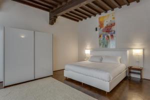 サン・カシャーノ・イン・ヴァル・ディ・ペーザにあるPalazzo Tempiの白い壁のベッドルーム1室(白いベッド1台付)