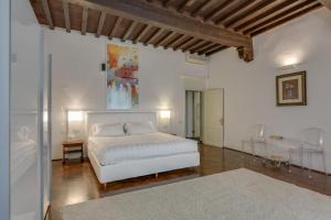 a white bedroom with a bed and a table at Palazzo Tempi in San Casciano in Val di Pesa
