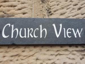 un cartello che dice la vista della chiesa su un muro di pietra di Churchview a Townhill
