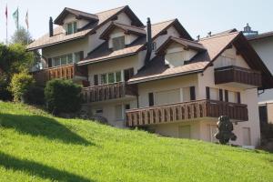 a large house on top of a grassy hill at Haus Flumser-Hockli - CharmingStay in Flumserberg