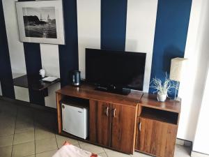 a living room with a television on a wooden entertainment center at Pensjonat Tahiti in Rowy