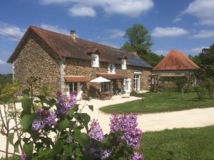 a stone house with purple flowers in front of it at La Rame in Chalais