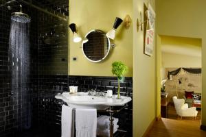 a bathroom with a sink and a mirror at Hotel De' Ricci - Small Luxury Hotels of the World in Rome