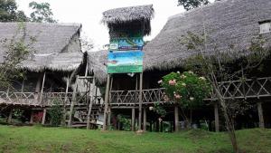 a large building with a thatched roof and a tree at Lodge Jungle Wolf Expeditions in Yucuruche