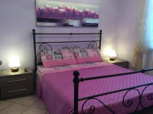 a bedroom with a bed with pink sheets and pillows at Tenuta Fagnani in Lucca +69 photos