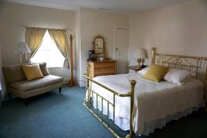 a bedroom with a bed and a chair and a window at The Salem Inn in Salem