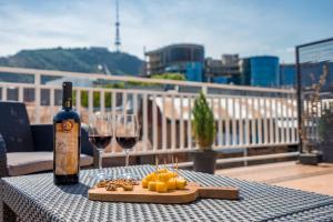 a table with a bottle of wine and two glasses at Hotel Imperial House in Tbilisi City
