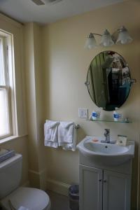 a bathroom with a sink and a toilet and a mirror at The Salem Inn in Salem