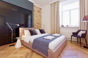 ein Schlafzimmer mit einem großen Bett und einem Stuhl in der Unterkunft Vilnius Apartments & Suites - Town Hall in Vilnius