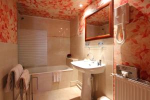 a bathroom with a sink and a bath tub at Hotel de la Bretonnerie in Paris